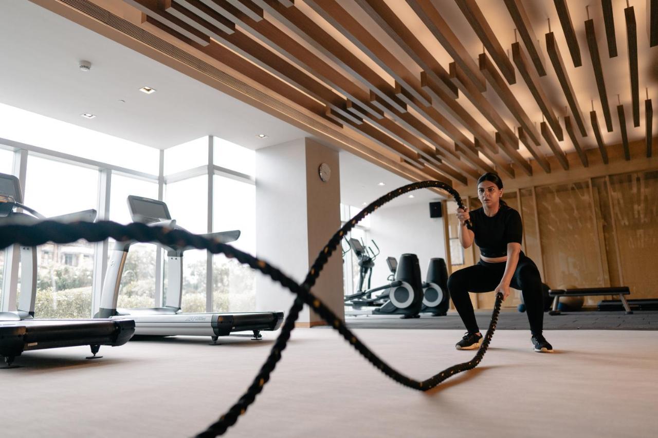 Hyatt Regency Ahmedabad Otel Dış mekan fotoğraf A woman using battle ropes
